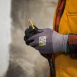 a person wearing gloves holding a pair of scissors