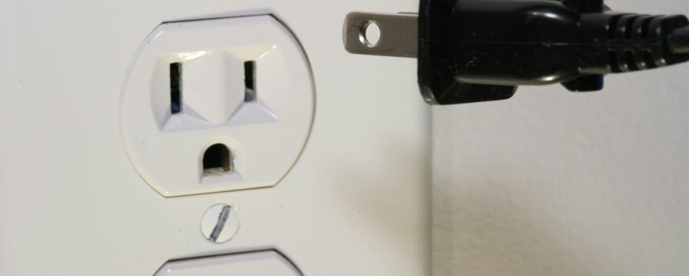 black male plug in front of electric socket