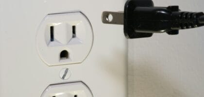black male plug in front of electric socket