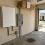Finished wall-mounted home battery and panel in a Citrus Heights garage
